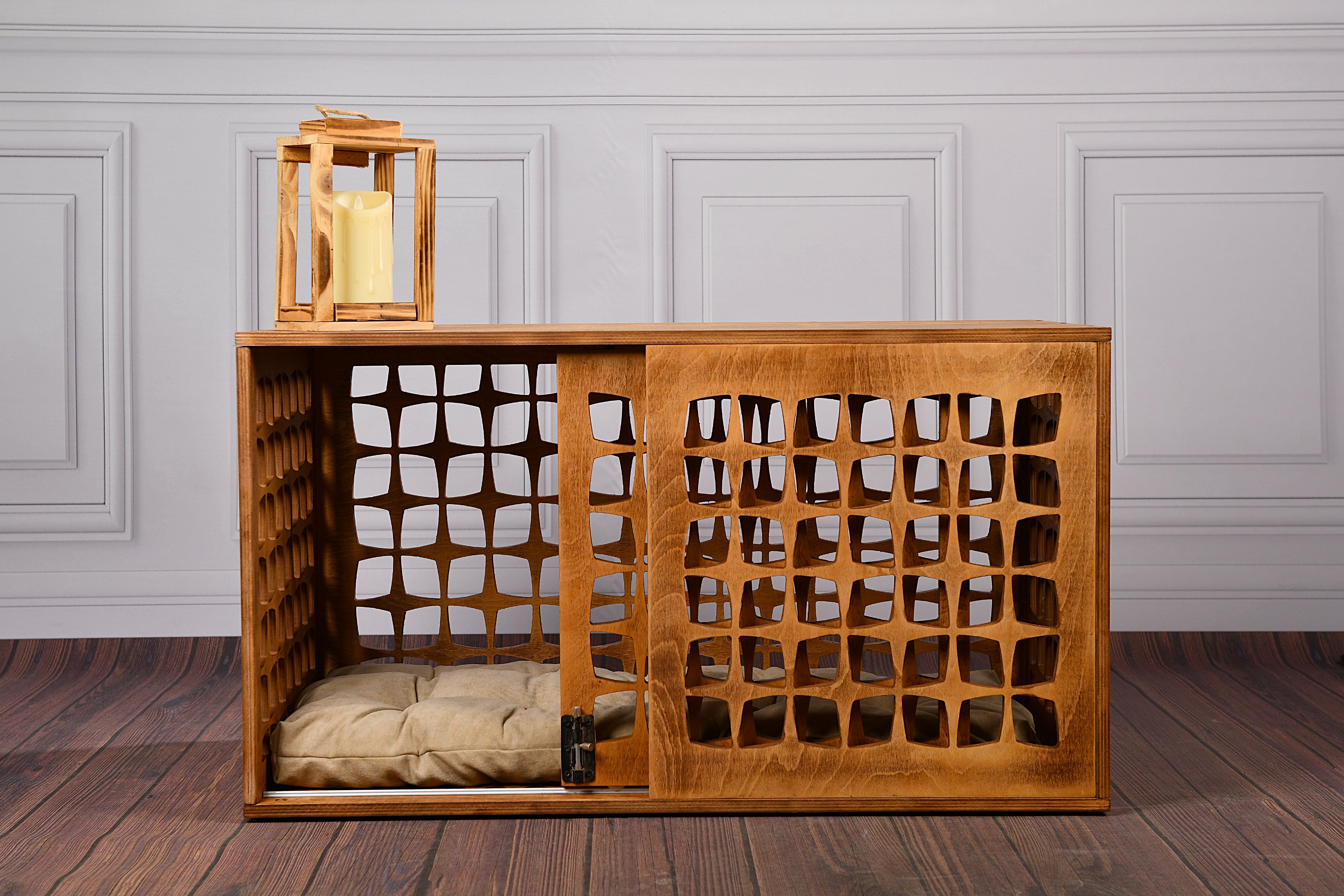 Wooden pet crate with lattice design on a wooden floor against a gray paneled wall.
