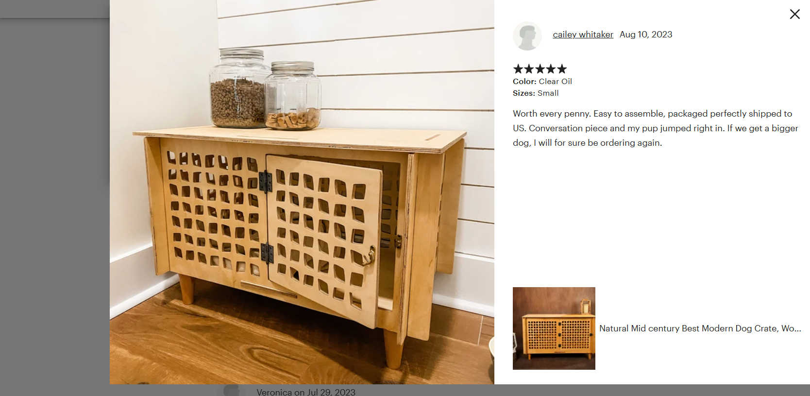 Wooden pet crate with lattice design on a wooden floor against a white wall.